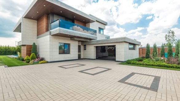 pexels-photo-8134845-8134845 Elegant modern house exterior with lush greenery and ample driveway space.